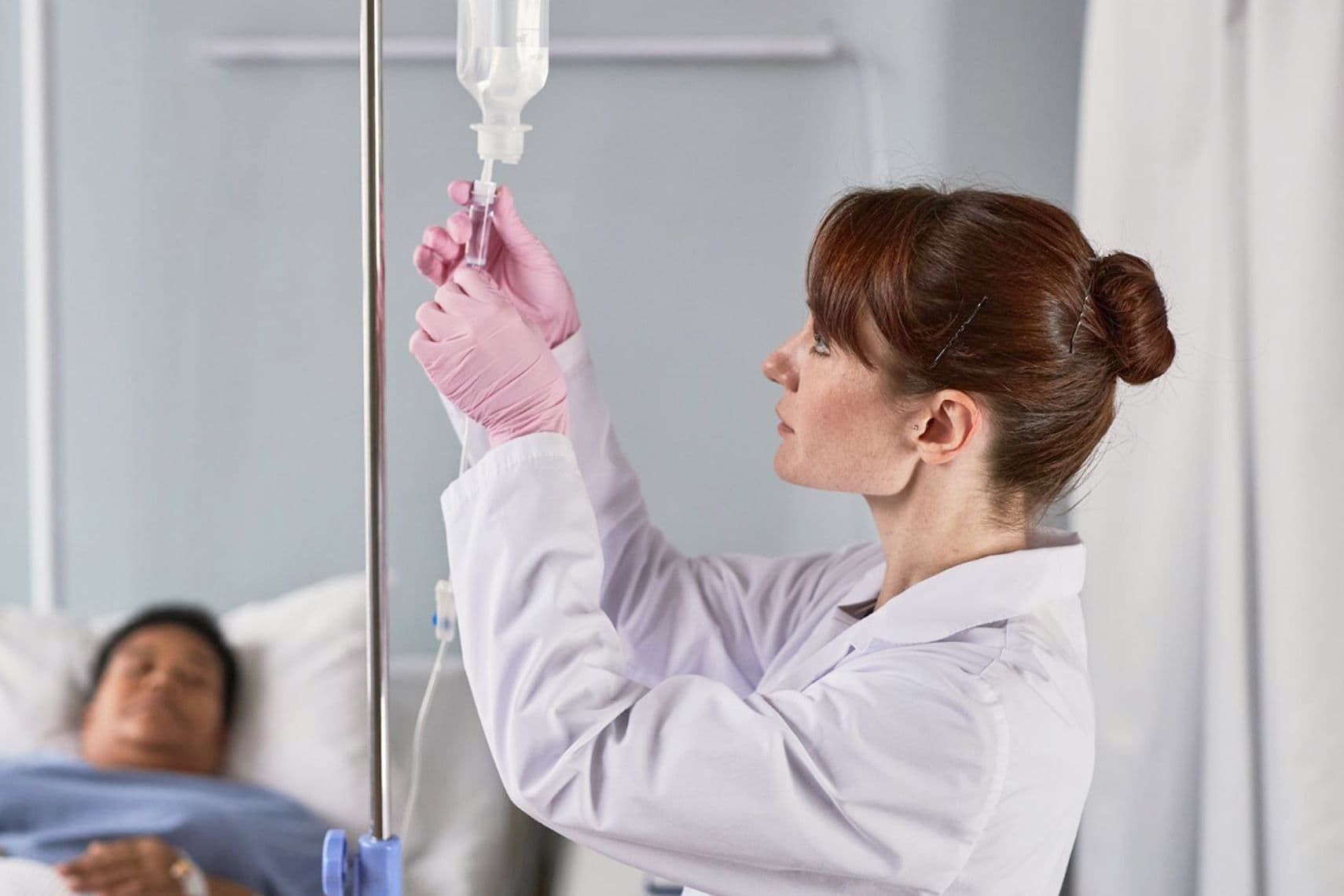 Девушка-врач ставит капельницу пациенту